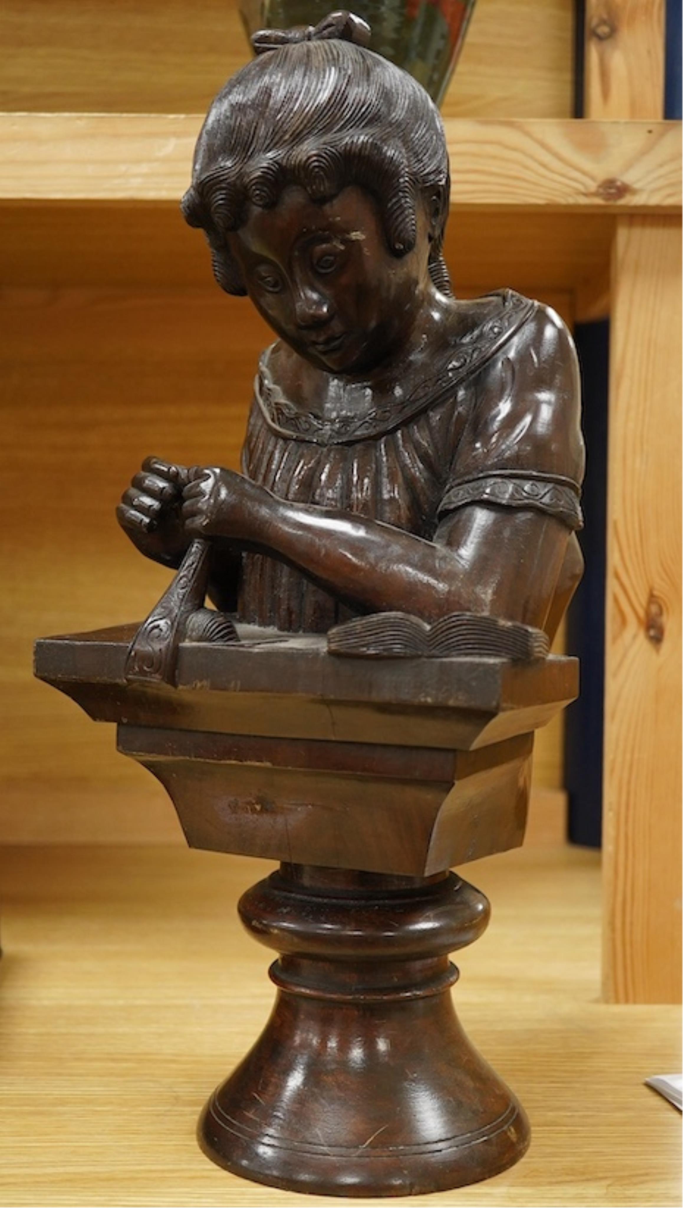 A carved wood bust of a girl sewing, 47cm high. Condition - two old cracks to the back of carving